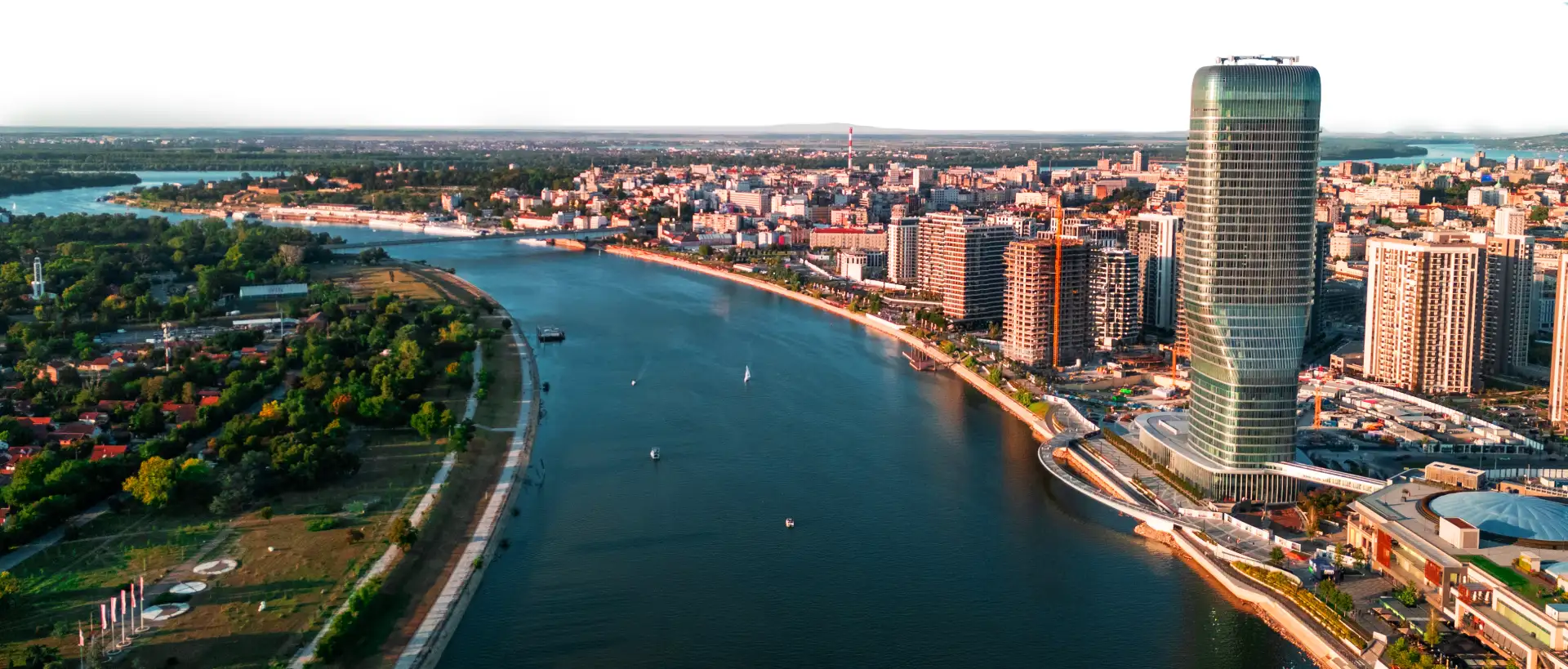 3d11dffa472e5240ee7e95e6d6b326f2857ec3a01-1 Wide panoramic view of the Sava River: Belgrade Tower and Galerija shopping mall on the right bank, with the greenery of New Belgrade on the left.