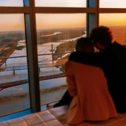 isplaniraj_posetu1_1 An embracing couple enjoys a panoramic view of Belgrade and the river during sunset at the Belgrade 360 Deck.